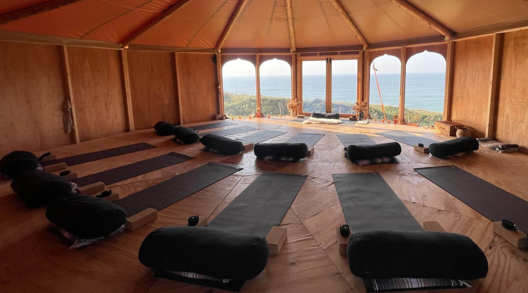 The Zen Den Yoga Studio setup showing 13 Manduka yoga mats looking out towards the sea