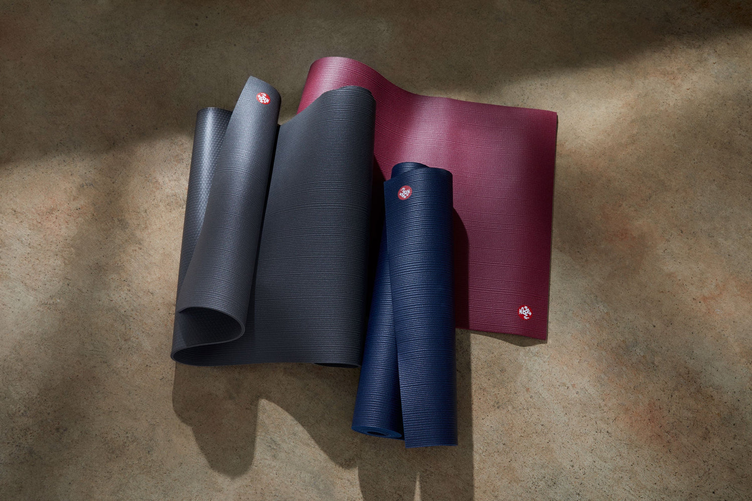 manduka pro mats on the floor in thunder, verve and midnight colors